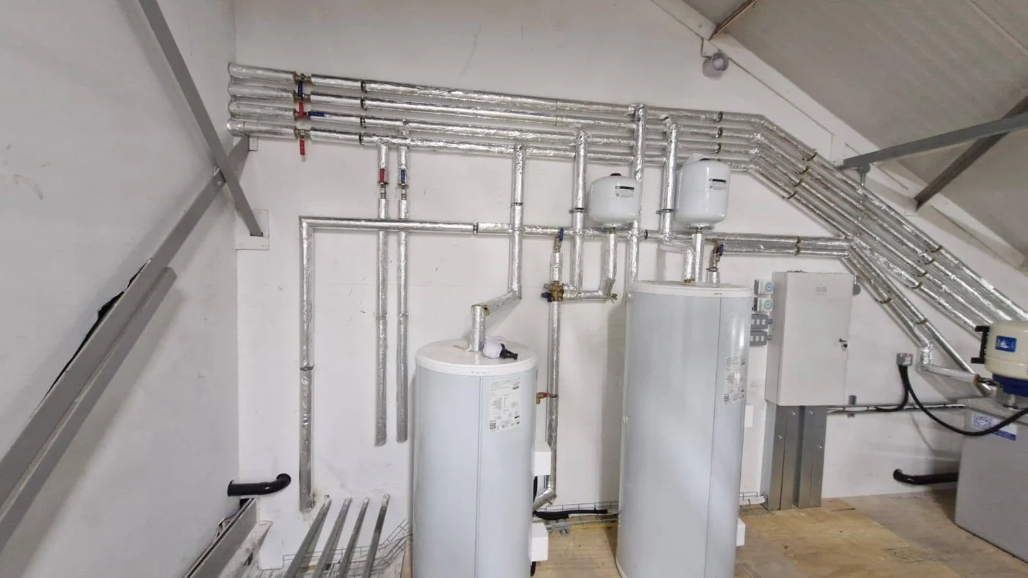 Plumbing and heating plant installation with cylinders and neatly arranged insulated pipework